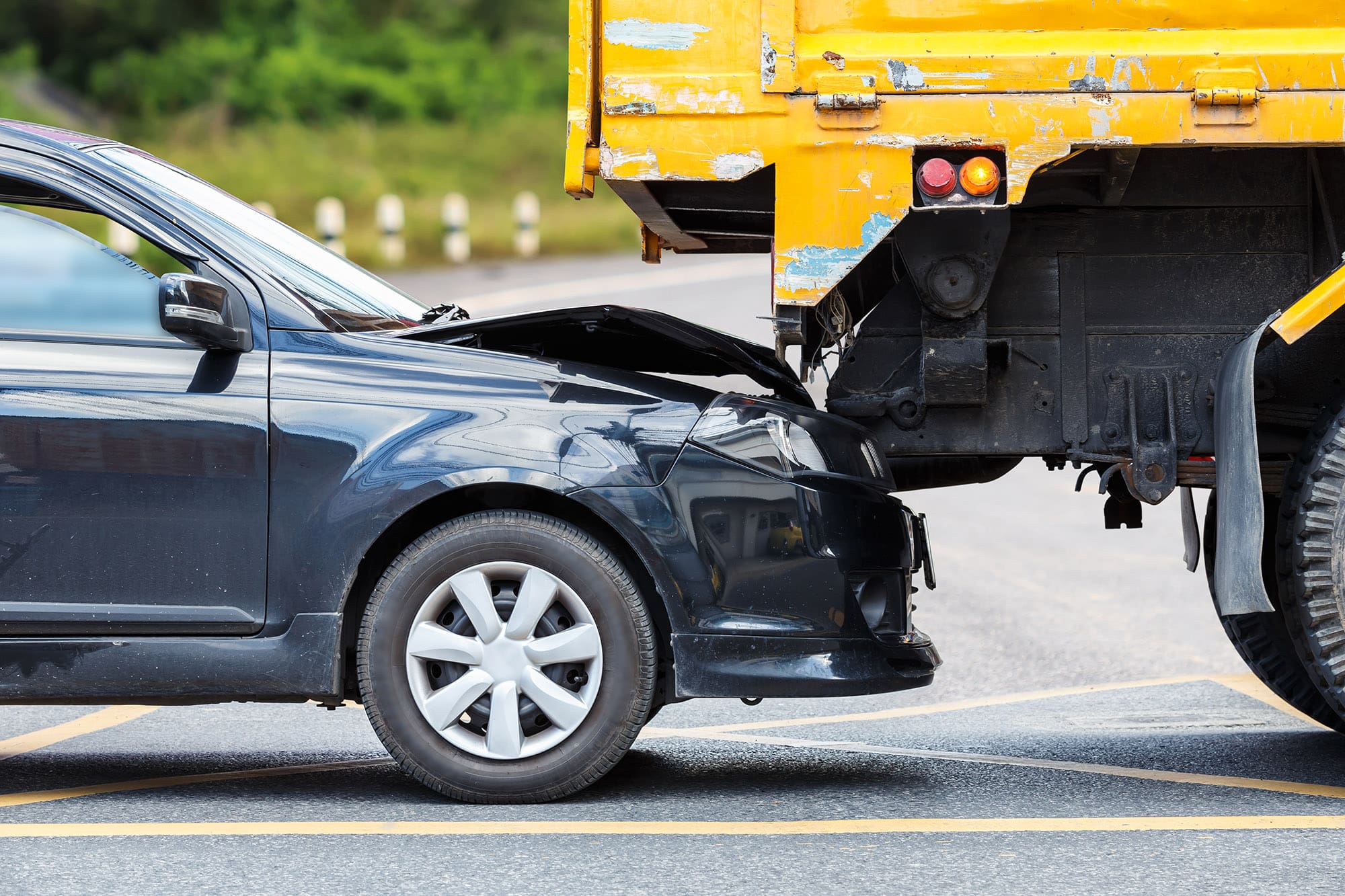Accident on the road involving black car and yellow truck