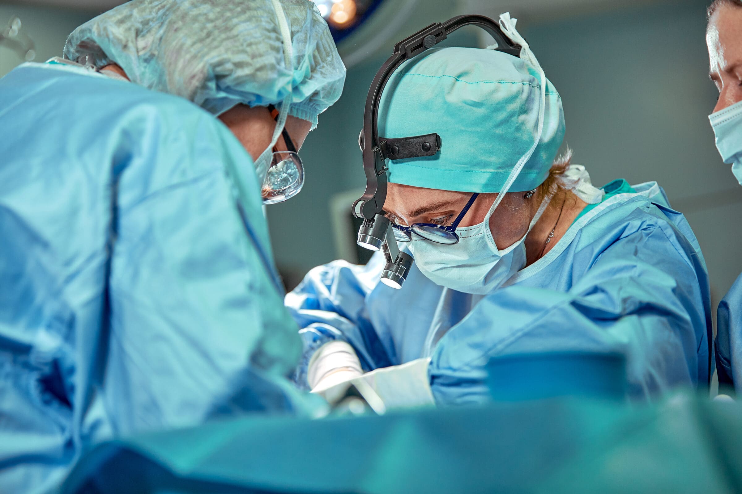 Group of surgeons looking at patient on operation table during their work Group of surgeons looking at patient on operation table during their work.